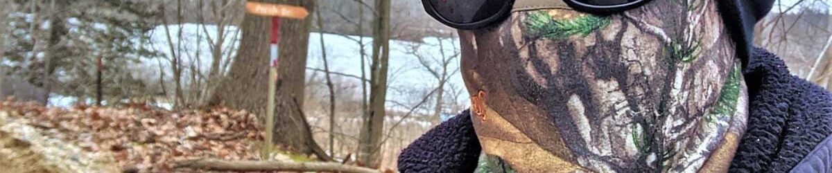 Picture of a person with a camoflage gaiter, sunglasses, and sock hat on out in the woods. Our title is below: How the VA Measures Skin Coverage for Burns or Eczema.